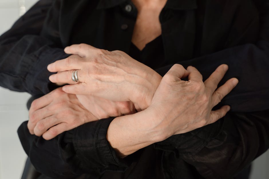 A heartfelt embrace showing close-up of hands in black clothes, conveying love and connection.